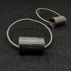 Pair of oxidized sterling silver Log Hoop Earrings on a dark surface