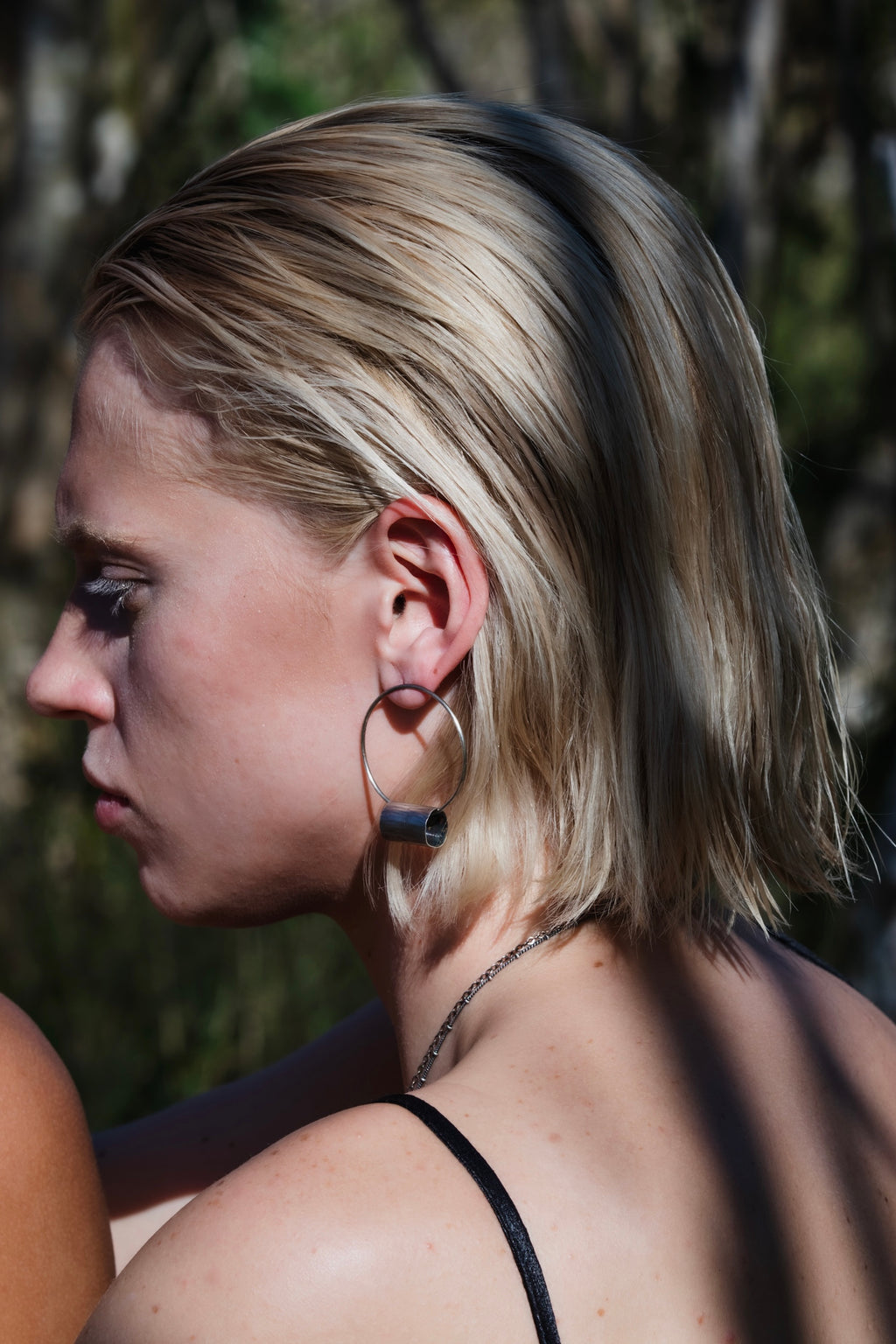 Side view of model wearing the oxidized silver Log Hoop Earring